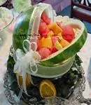watermelon baby carriage centerpiece with assorted fruit and white sheer ribbon