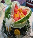 watermelon baby carriage centerpiece with assorted fruit and white sheer ribbon