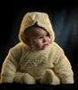 a baby sitting in a cute winnie the pooh outfit
