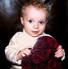 cute baby boy in cream sweater holding onto a red valentine heart box