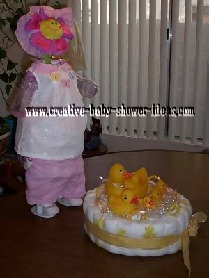 sunflower doll diaper cake standing on doll stand next to 1 tier duck diaper cake