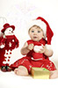 cute baby dressed in santa dress holding present