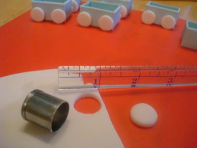 Adding wheels to train cars, also cut out slightly smaller circles in dark blue for wheel centers. 