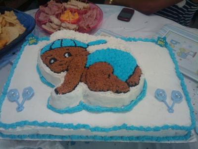 white sheet cake with baby boy crawling design on top