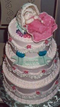 3 tier pink baby blanket cake with baby sleeping in bassinet