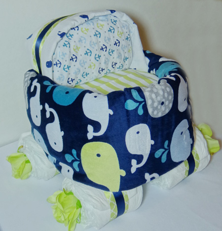 blue and green diaper baby carriage with whales and stripes blue blanket wrapped around diaper stroller